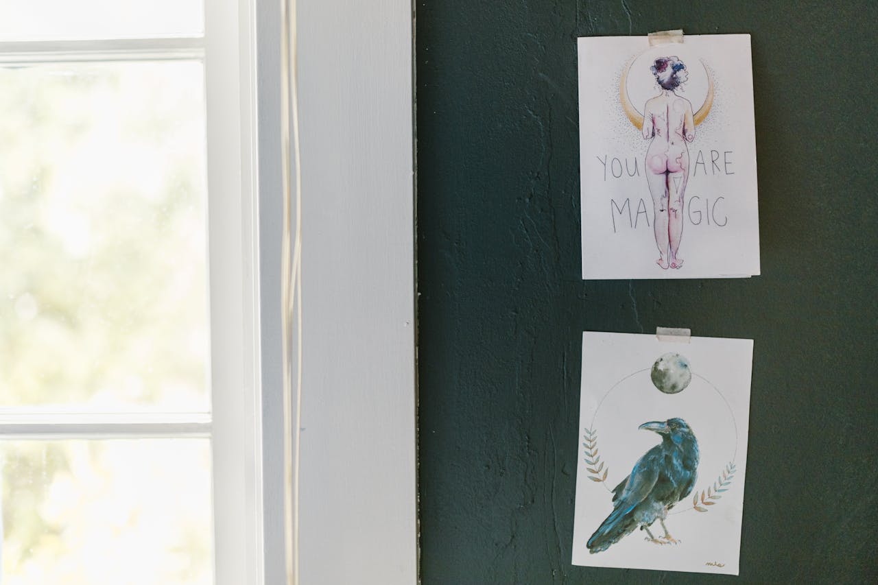 Two artistic posters with inspiring messages displayed on a dark green wall.
